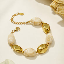 Neutral organic resin bracelet with irregular pebble beads and polished gold stainless steel details