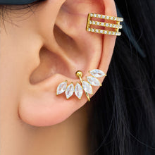 Model wearing a gold leaf ear cuff with sparkling marquise stones, styled alongside gold ear jewelry