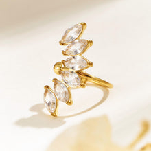 Gold-tone leaf ear cuff displayed upright on a neutral background, showing clear marquise stones and open rounded ends