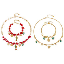 Ocean animal charm necklace and bracelet collection worn by model with turtle, shell, starfish and coral-inspired pendants for wholesale boutique buyers