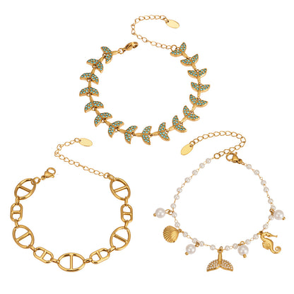 Ocean charm bracelet collection with fish tail, shell, faux pearl and marine-inspired designs for wholesale boutique buyers