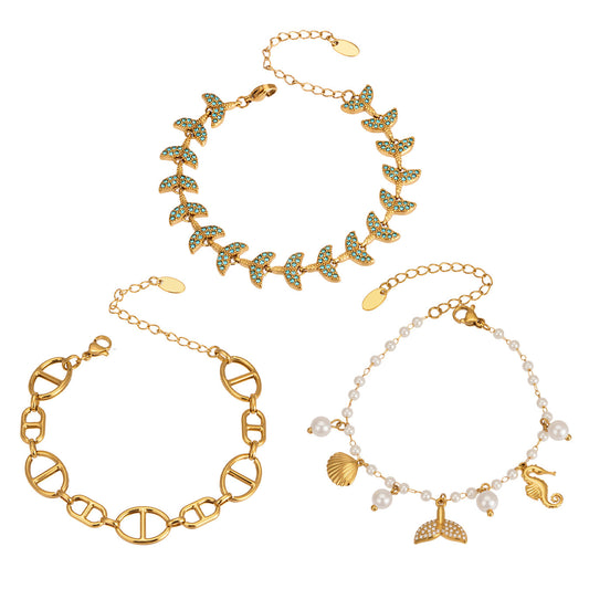 Ocean charm bracelet collection with fish tail, shell, faux pearl and marine-inspired designs for wholesale boutique buyers