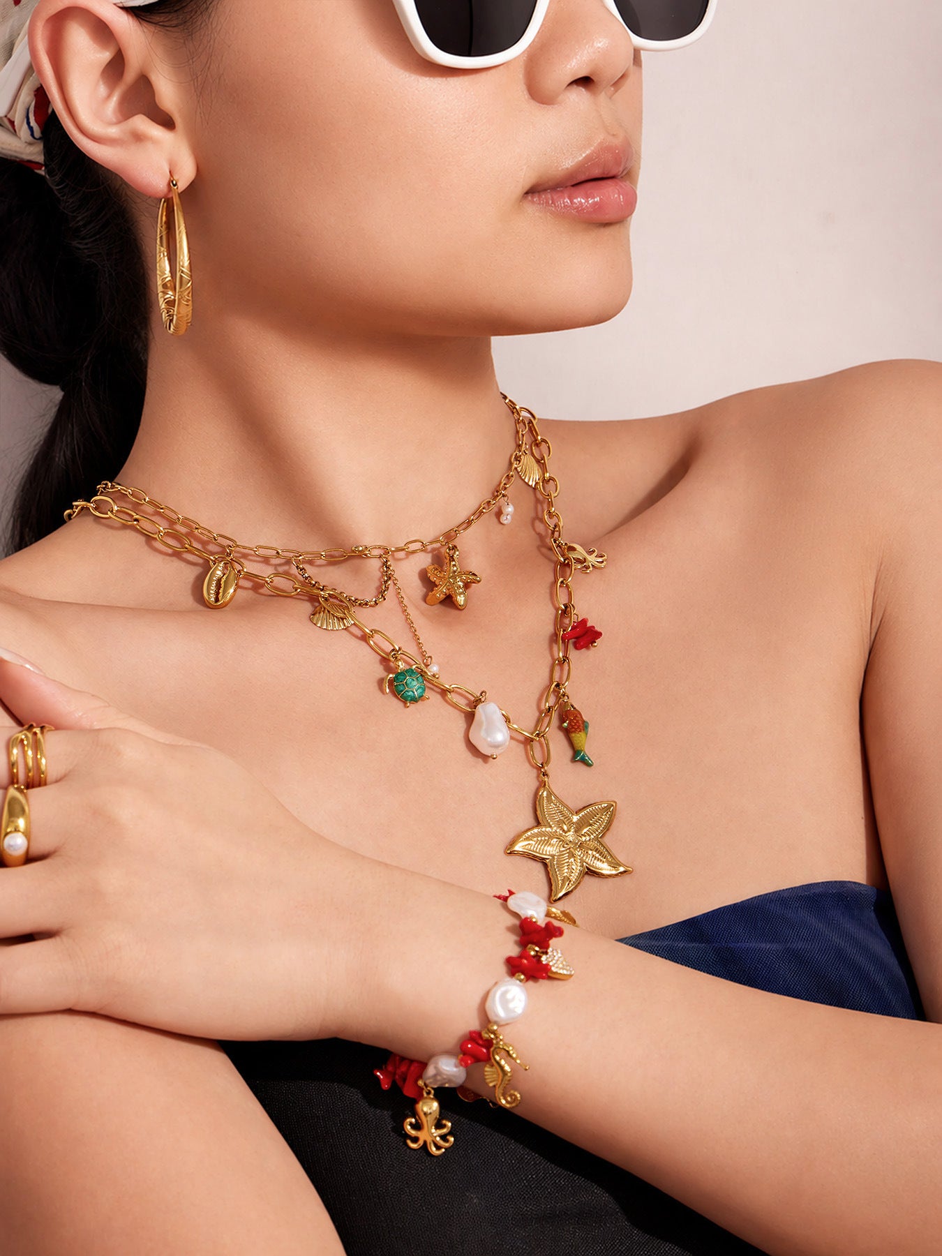 Ocean charm bracelet worn on wrist with red shell and pearl details for resort jewelry and boutique displays