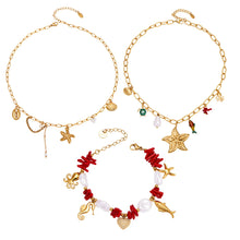 Ocean charm necklace and bracelet collection worn by model with starfish, fish tail, pearl and shell details for wholesale boutique buyers