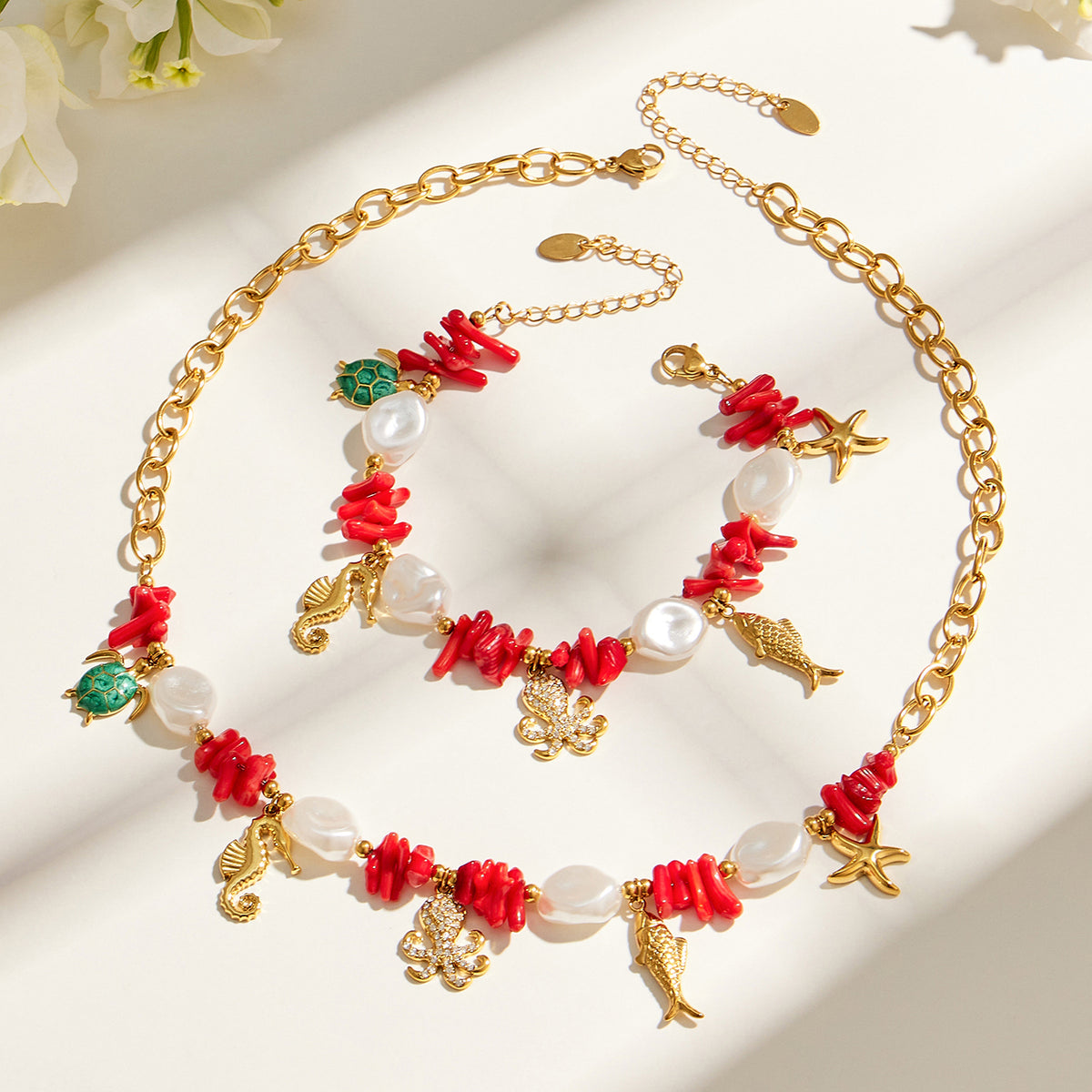 Ocean charm necklace and bracelet flat lay with red bead and marine animal details