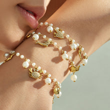 Close-up of gold ocean charm pearl bracelets with stainless steel marine charms and pearl accents