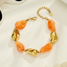 Orange chunky resin bracelet with irregular beads and sculptural gold-tone details