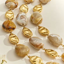 Close-up of irregular resin beads and sculptural 18K PVD gold stainless steel accent beads