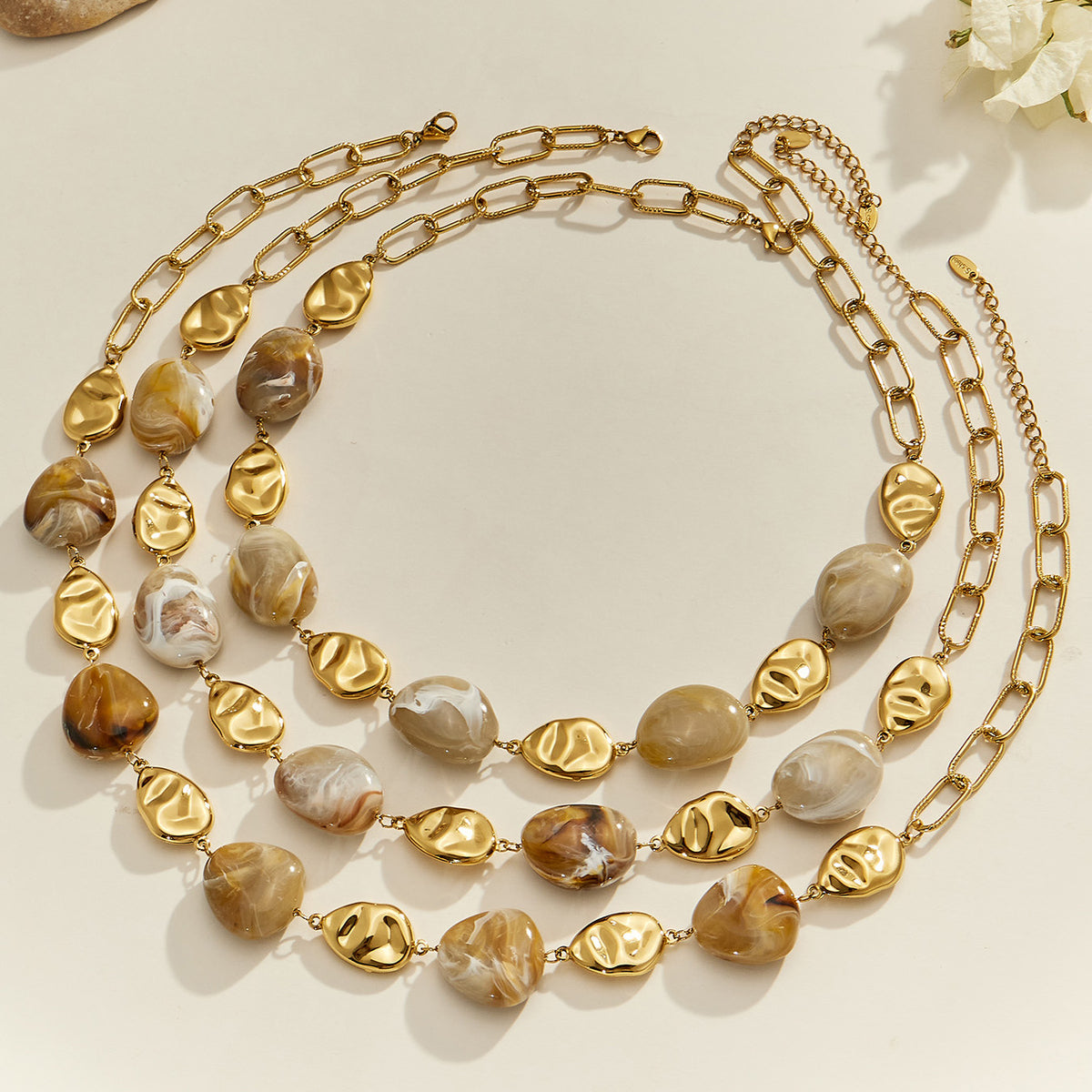 Layered organic resin necklaces with irregular resin beads and gold-tone stainless steel accents displayed together