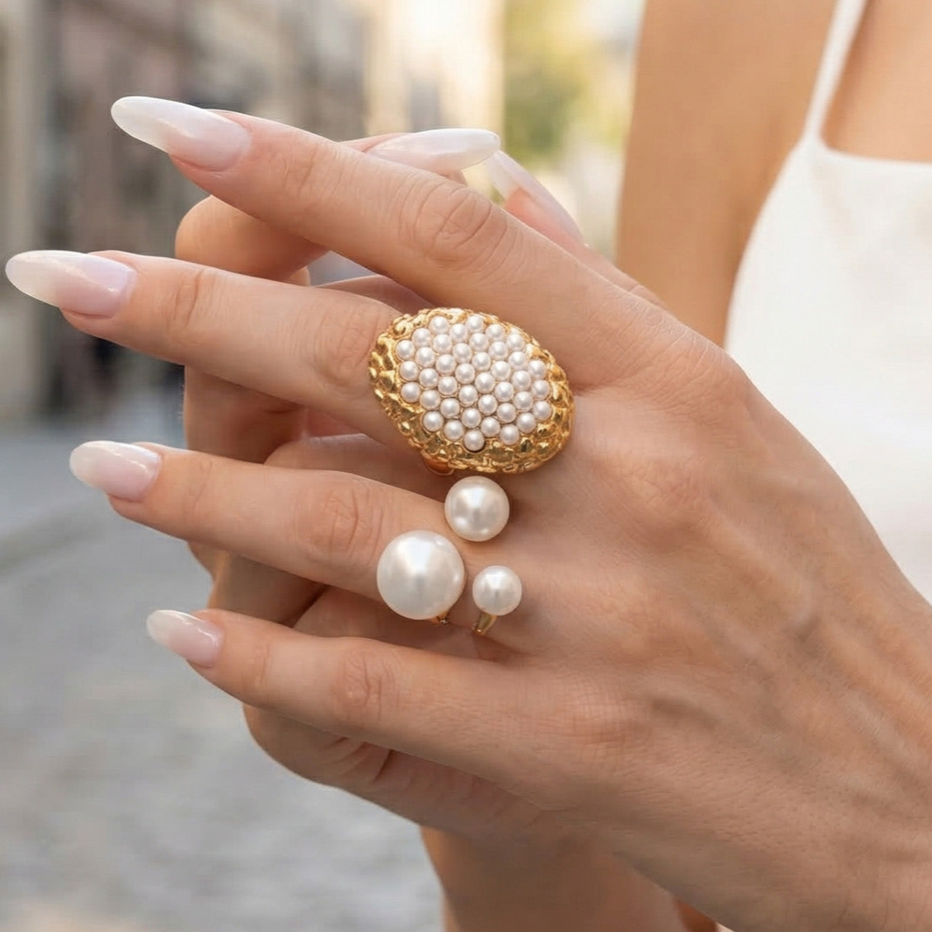 Oversized oval faux pearl cluster statement ring worn on a model hand