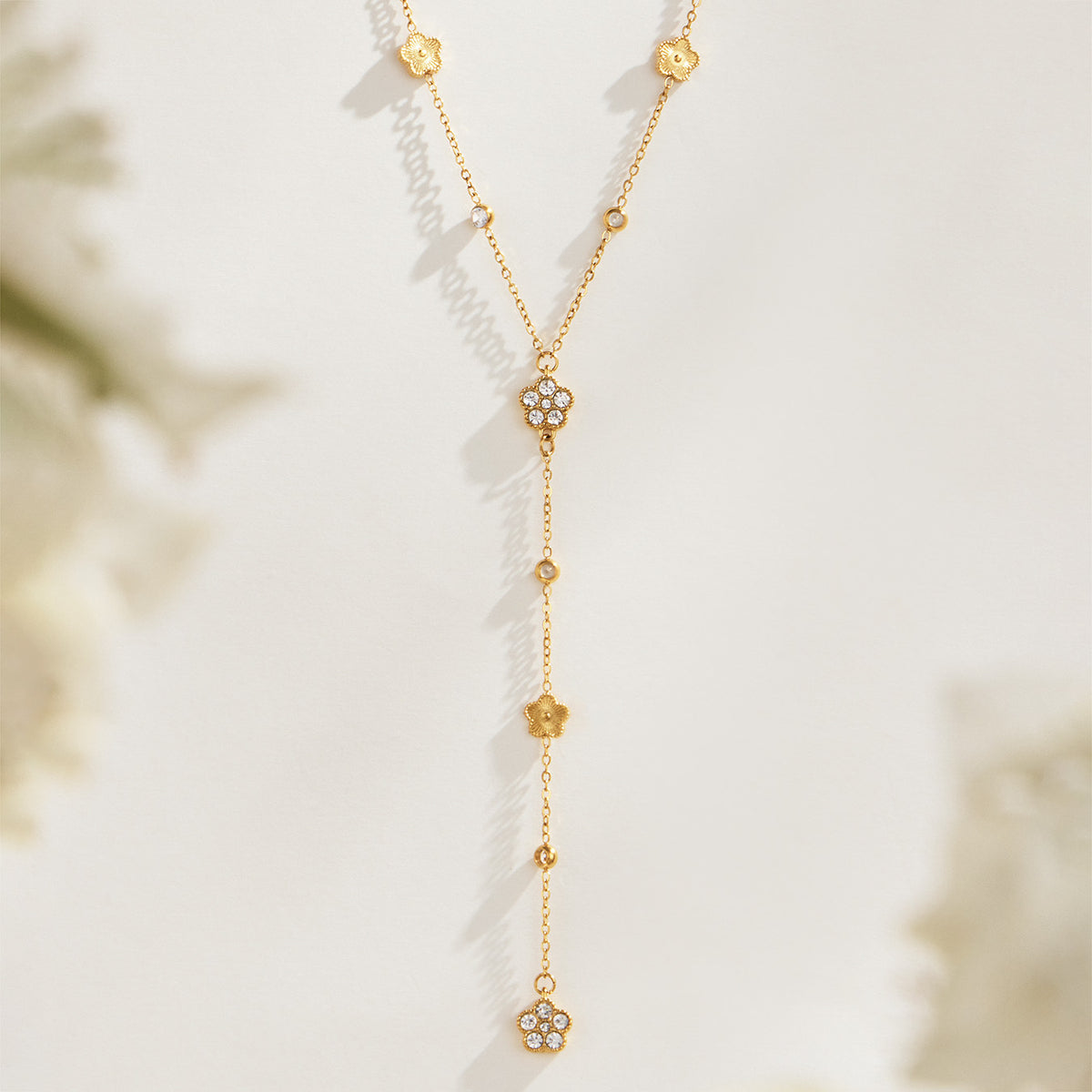 P015 gold-tone floral zircon Y necklace displayed with flower motifs and elongated drop