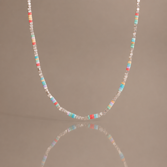 Colorful natural stone beaded necklace with pastel square beads and stainless steel details displayed with soft reflection