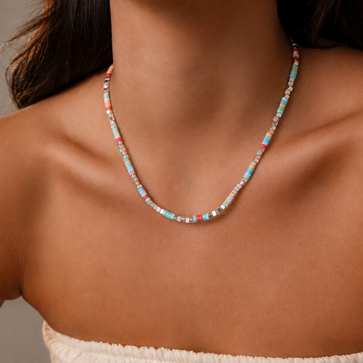Model wearing colorful natural stone heishi bead necklace with pastel beads for summer boutique jewelry styling