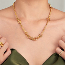 Gold oval link chain necklace worn alone on model with a minimalist neckline