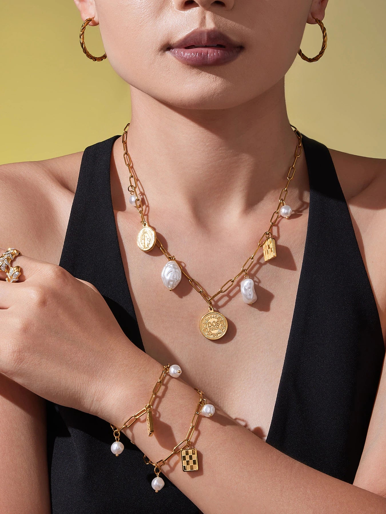 Matching gold paperclip charm necklace and bracelets with checkerboard and pearl-look charms