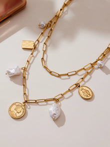 Close-up of paperclip charm necklaces with coin, checkerboard and pearl-look charms