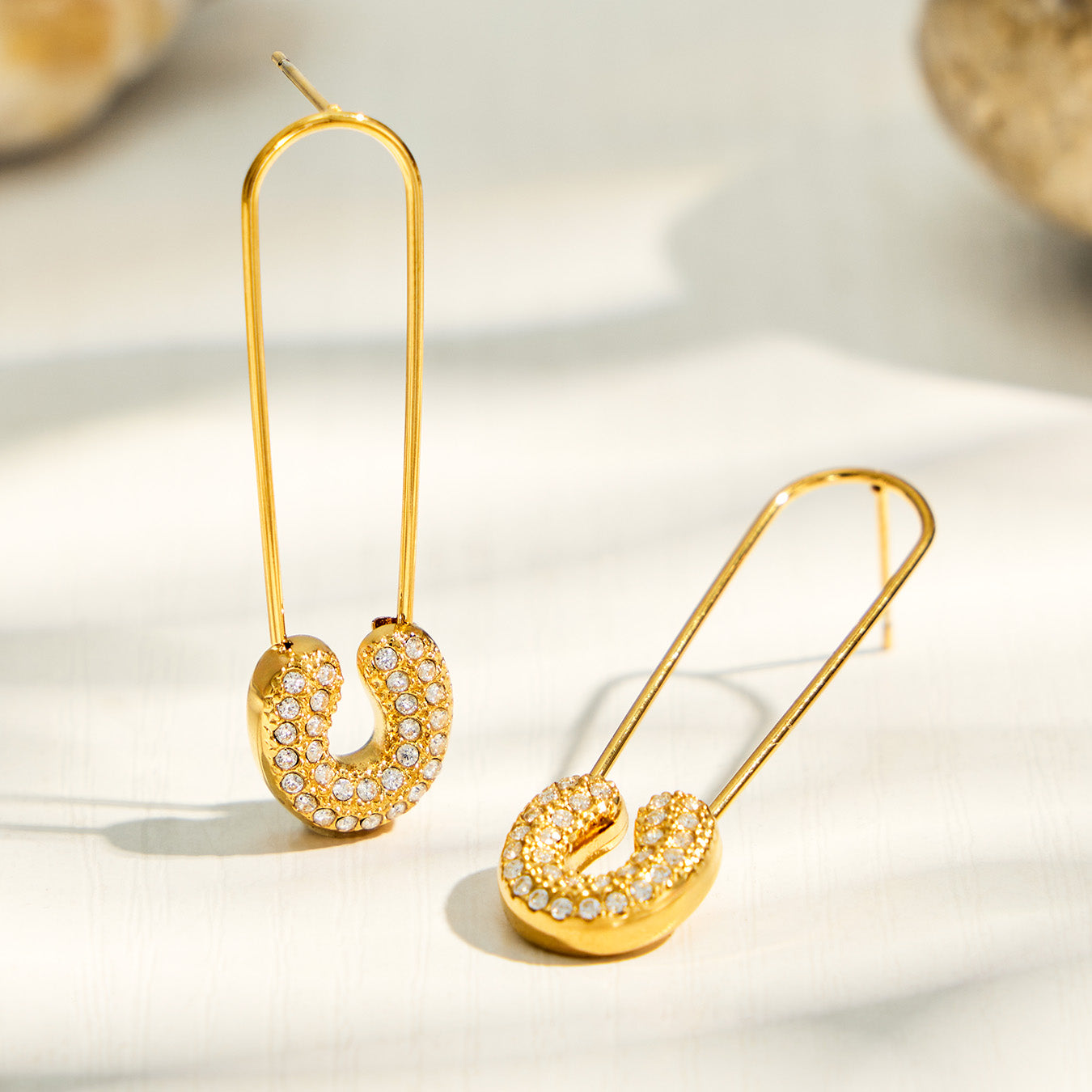 Paperclip drop earrings with clear cubic zirconia pendant in a styled product display