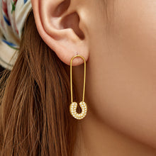Model wearing gold paperclip-inspired drop earrings from the side