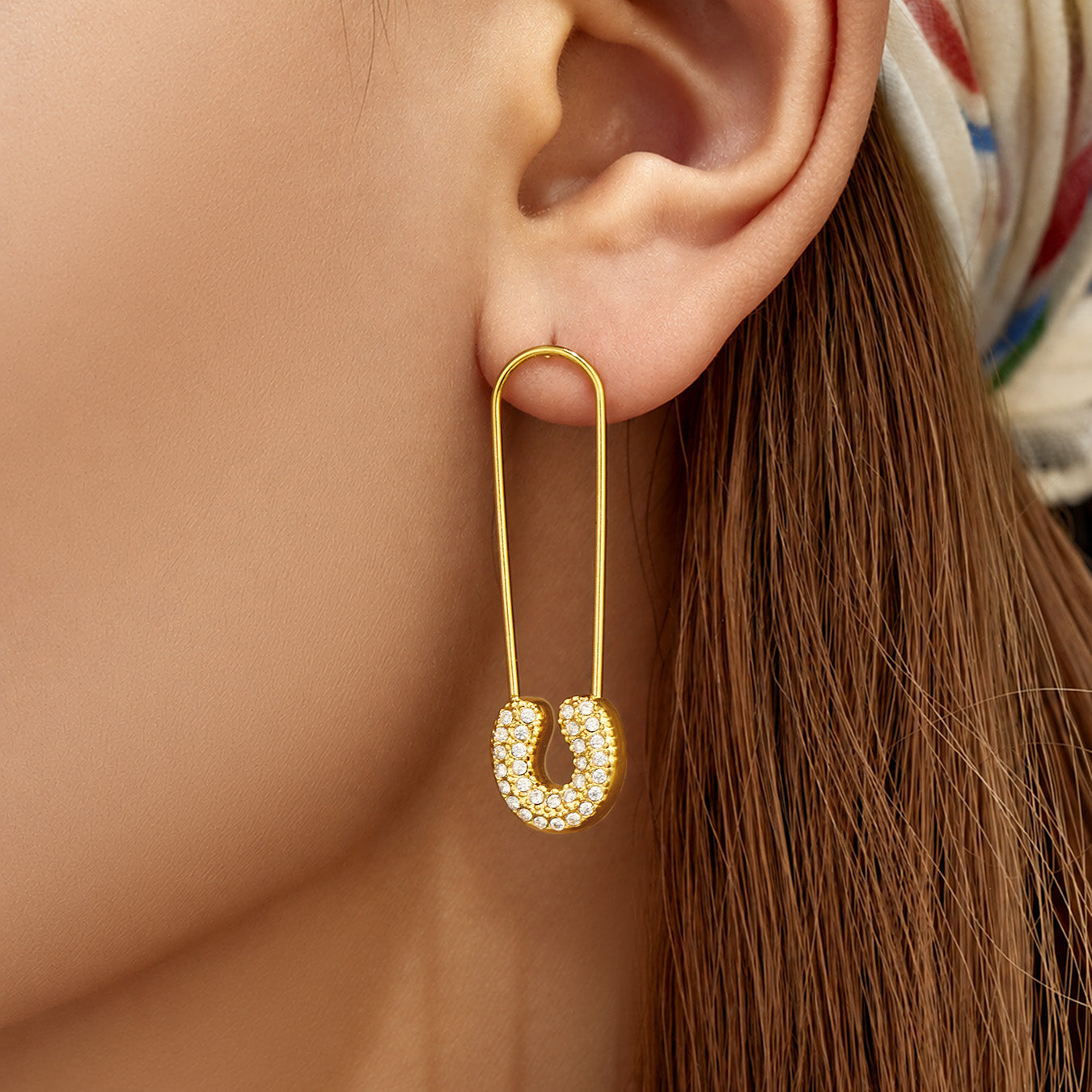 Front view of paperclip-inspired drop earrings worn on the ear