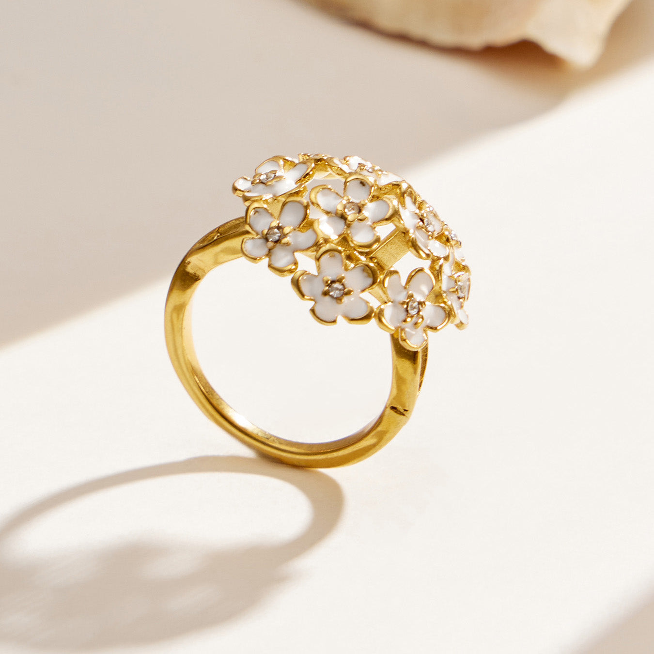 Gold 316L stainless steel pave cubic zirconia flower ring displayed on a light background