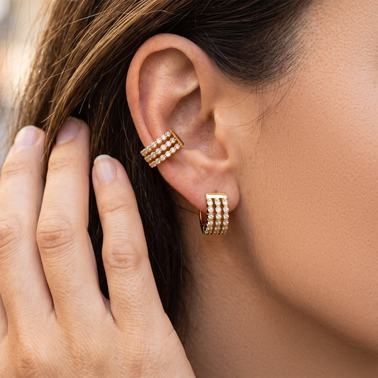 Close-up of a model wearing small triple-row pavé zircon huggie earrings