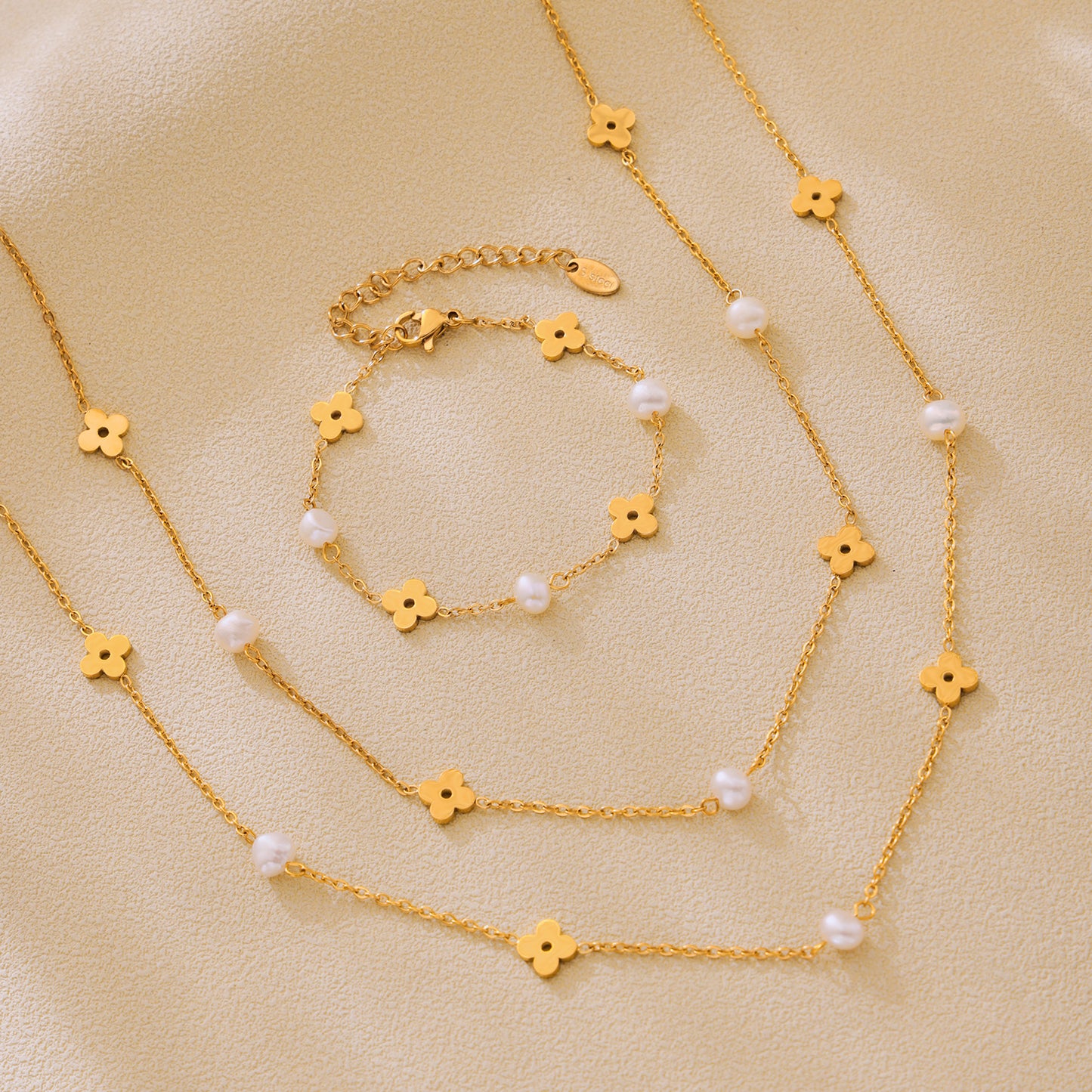 Freshwater pearl clover necklace and bracelet arranged together in a coordinated gold jewelry flat lay