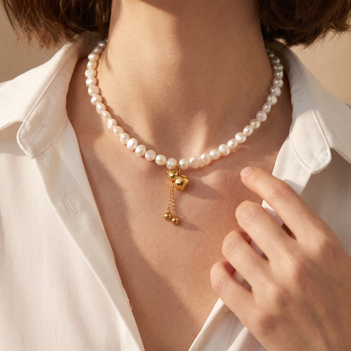 Freshwater pearl necklace with delicate gold charm detail