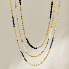 Close-up of the gold pearl necklace detailing