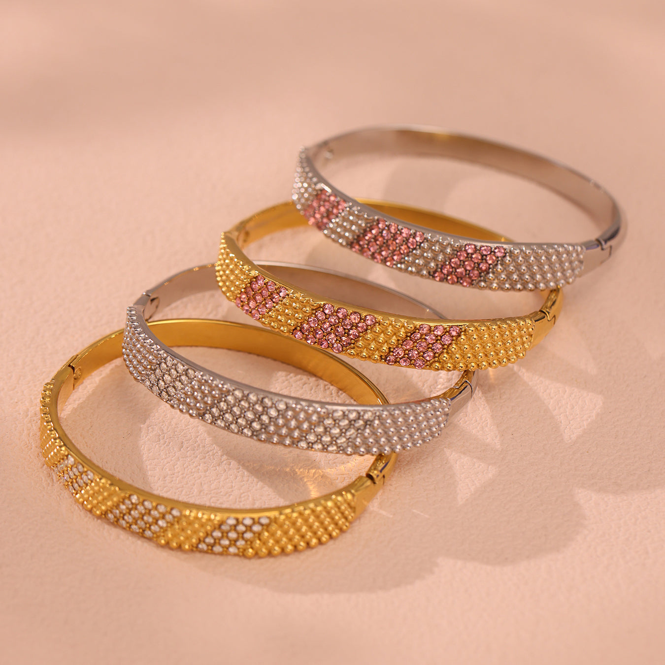 18k gold plated & stainless steel pink 5a zircon bangle set, displayed on textured surface
