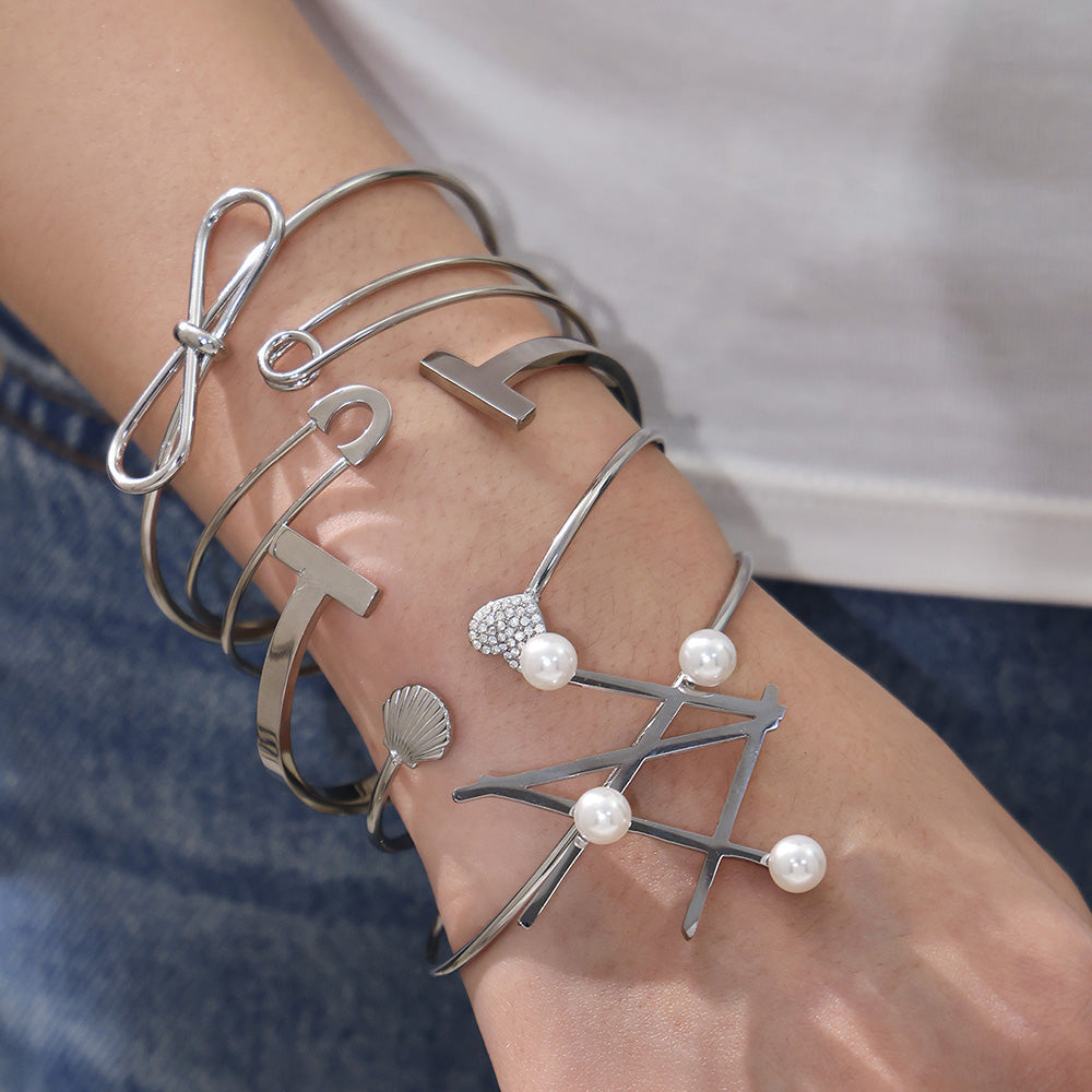 Model stacking polished silver geometric line & pearl open bangles, trendy minimalist accessory