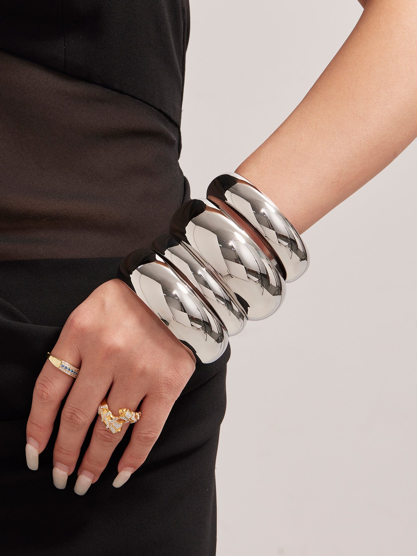 model wearing polished silver stainless steel wide cuff bracelets, front view, modern fashion accessory