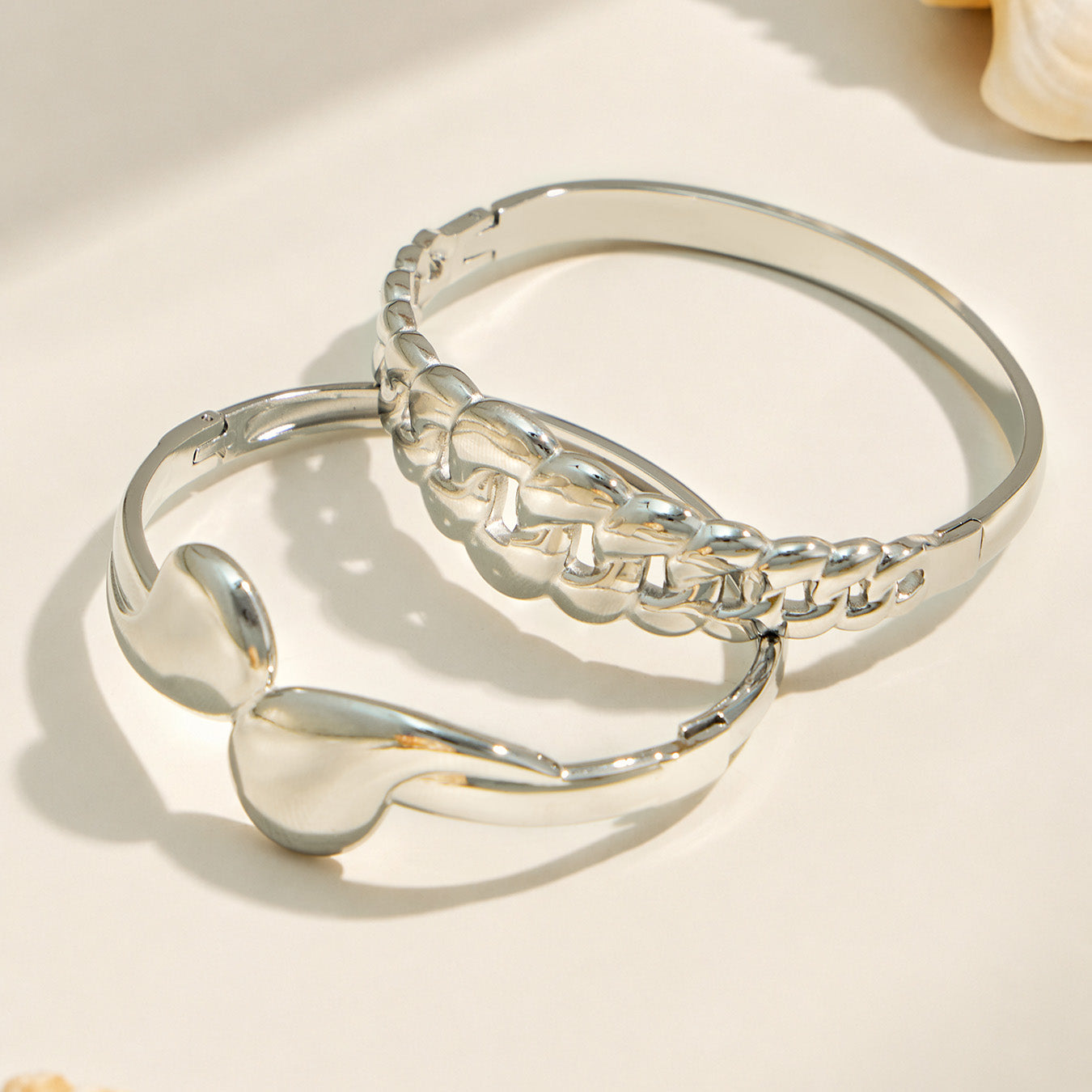 Polished steel teardrop and chain link bangle bracelets displayed together