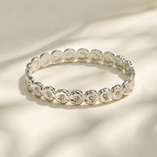Polished steel floral cubic zirconia hinged bangle on a light background