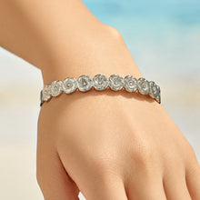Model wearing a polished steel floral bangle with clear cubic zirconia accents