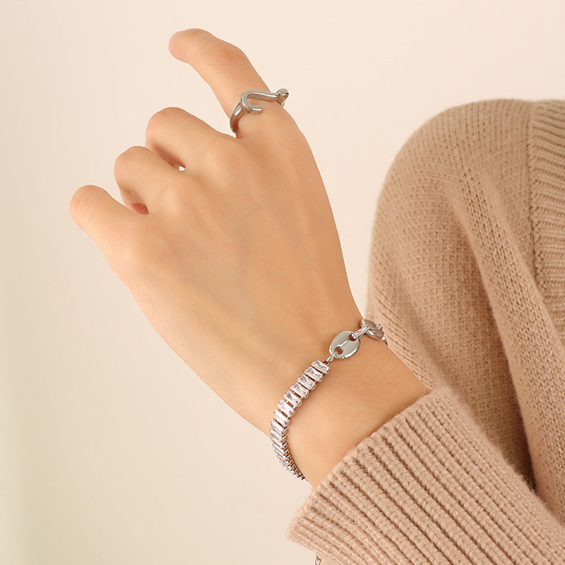 Close-up of a polished steel mixed-link zircon bracelet worn on the wrist