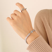 Close-up of a polished steel mixed-link zircon bracelet worn on the wrist