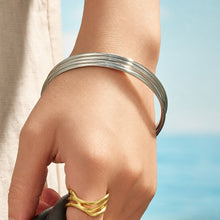 Model wearing a polished steel slim stackable bangle on the wrist