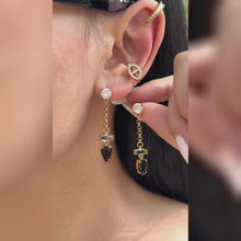 Gold-tone chain drop earrings with clear stone accents and black teardrop stones, shown on a model.