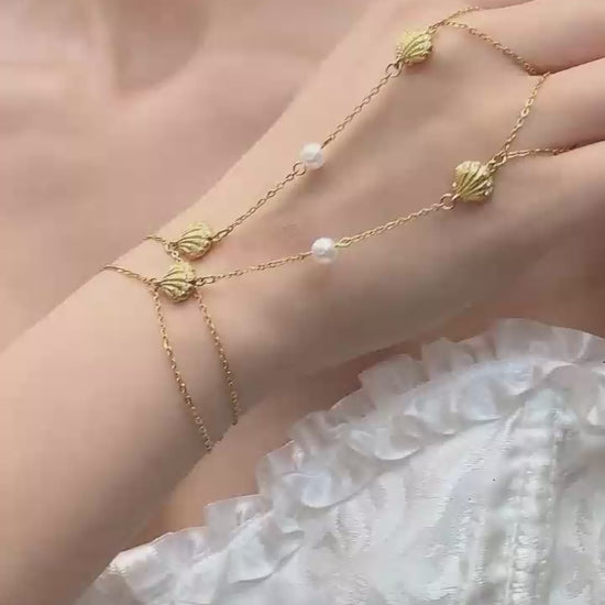 Video cover showing model wearing gold shell zircon pearl hand chain finger bracelet in 316L stainless steel summer ocean inspired jewelry by Miduoduo Jewelry