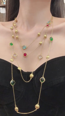 Colored glass stone station long necklace in 316L stainless steel with gold-tone beads, shown on model for wholesale jewelry buyers