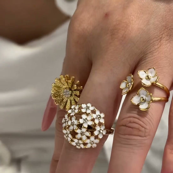 Model showcasing 316L stainless steel floral rings with daisy, enamel flower and CZ designs in 18K PVD gold finish