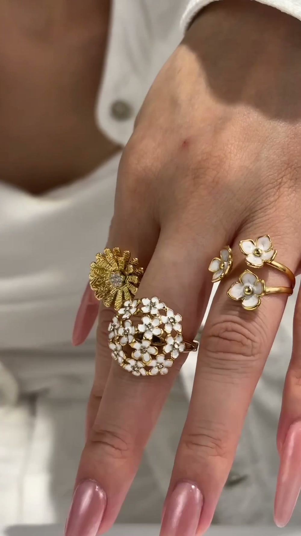 Model showcasing 316L stainless steel floral rings with daisy, enamel flower and CZ designs in 18K PVD gold finish