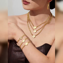 Video showing a model styling layered gold-tone zircon initial heart necklaces with matching bracelets