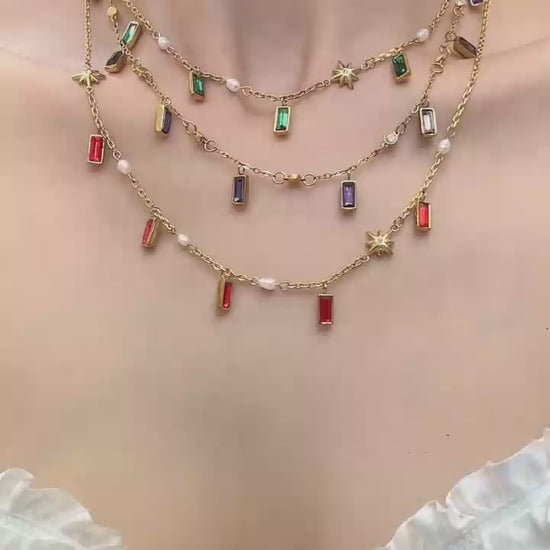 Model wearing colorful glass stone charm necklace with gold tone chain for summer vacation and boutique jewelry styling