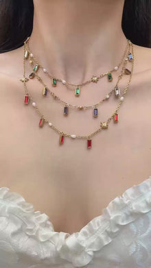 Model wearing colorful glass stone charm necklace with gold tone chain for summer vacation and boutique jewelry styling