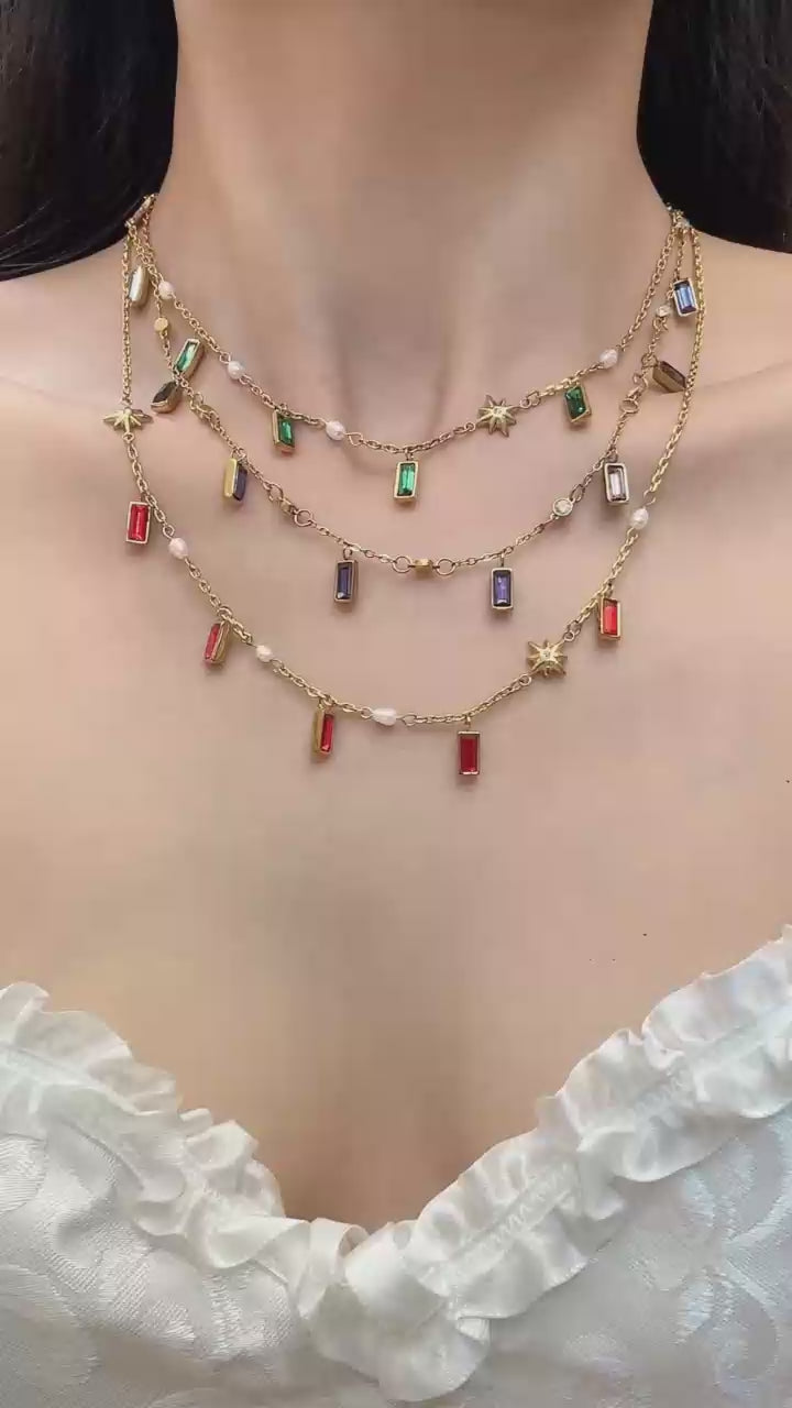 Model wearing colorful glass stone charm necklace with gold tone chain for summer vacation and boutique jewelry styling