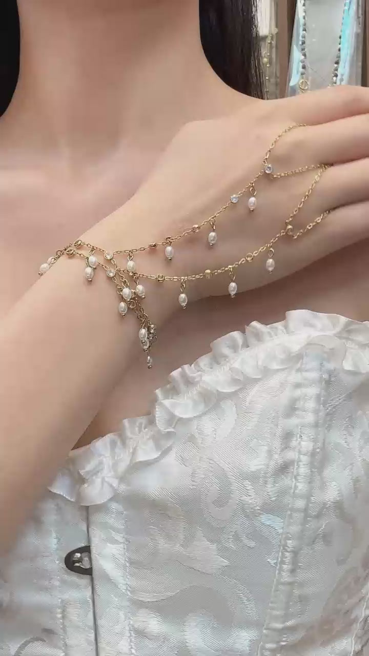 Video cover showing model wearing gold zircon pearl finger chain bracelet hand chain in 316L stainless steel elegant women jewelry by Miduoduo Jewelry