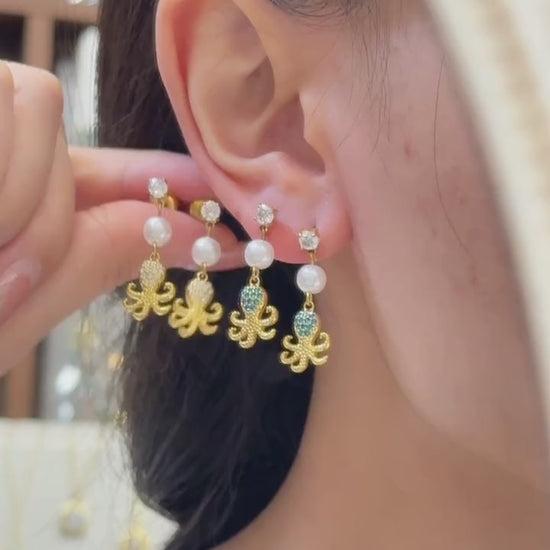 Video showcasing women wearing 316L stainless steel ocean charm pearl drop earrings in 18K PVD gold for resort beach jewelry styling