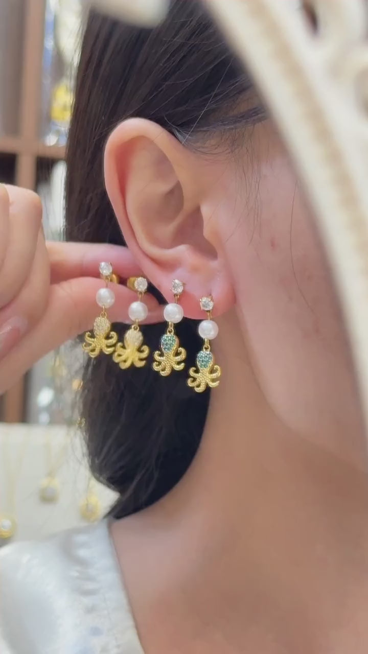Video showcasing women wearing 316L stainless steel ocean charm pearl drop earrings in 18K PVD gold for resort beach jewelry styling