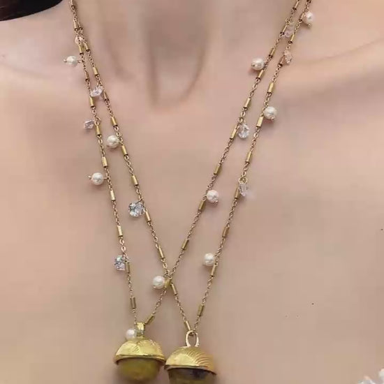 Video cover of model wearing gold shell pendant station necklace with scattered pearl and zircon beads in 316L stainless steel by Miduoduo Jewelry